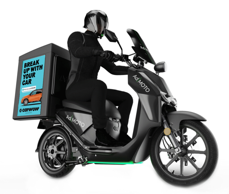 Sideways bike, with rider sat on it, with a carwow advertisement on the back